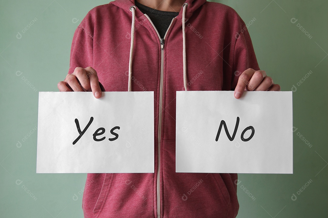 Um jovem segura um pedaço de papel com as palavras sim e não