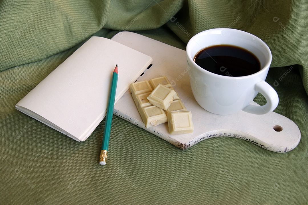 Lápis folhas para anotações café e chocolate sobre tábua