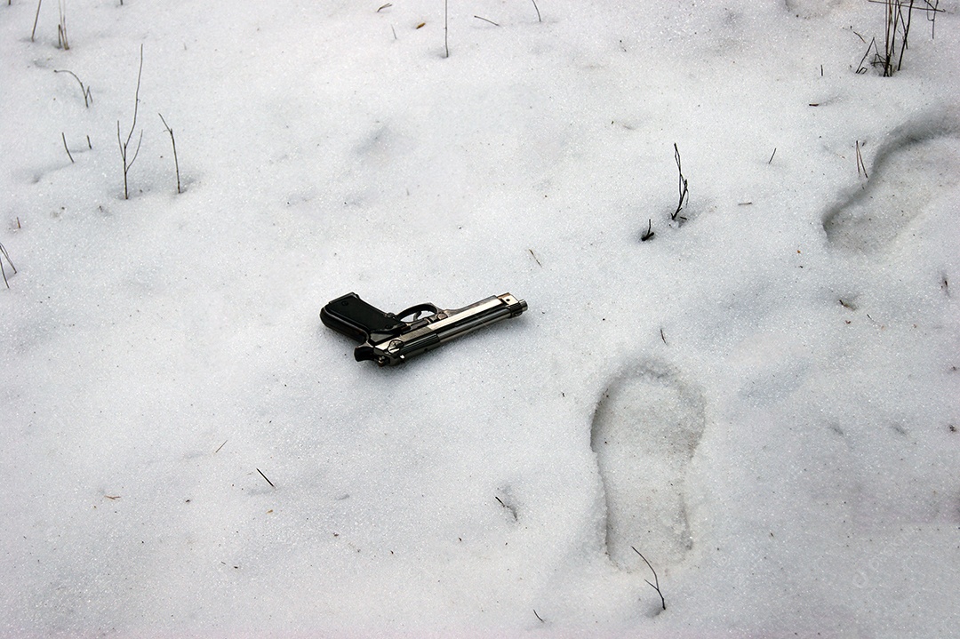 Arma na neve com pegadas ao lado