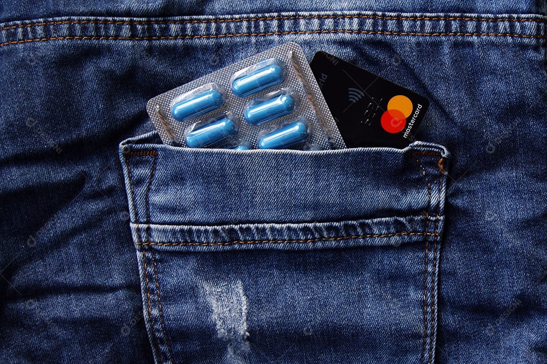 Cartela de comprimmido e cartão em bolso de trás de jeans