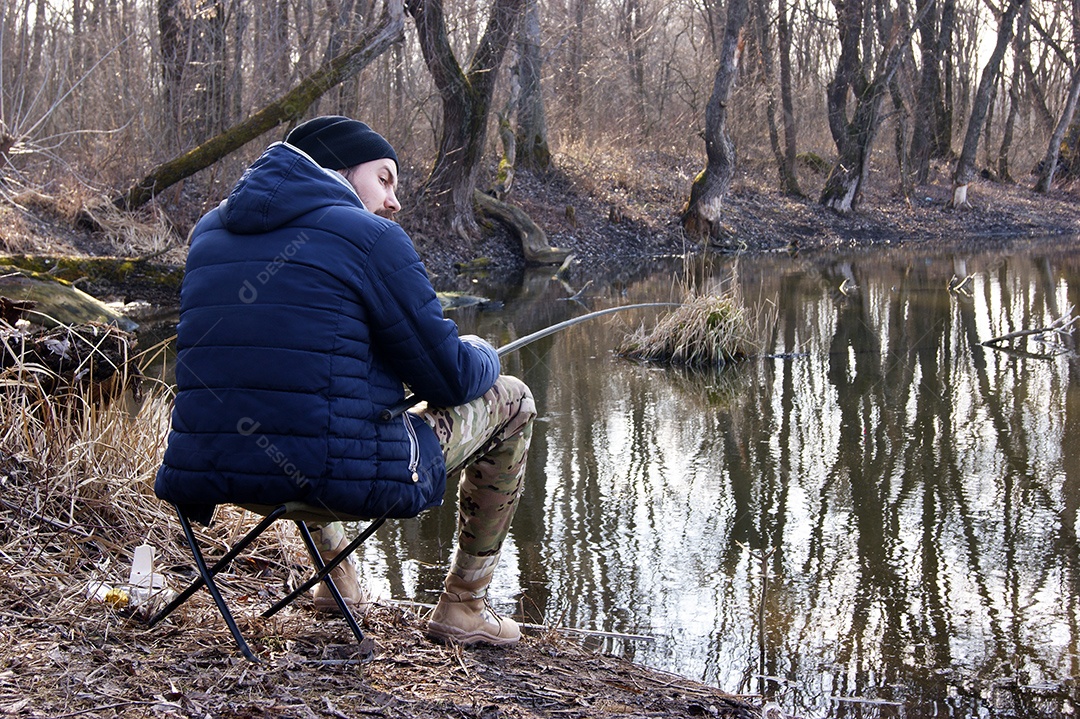 Vara de pesca nas mãos de um pescador no lago