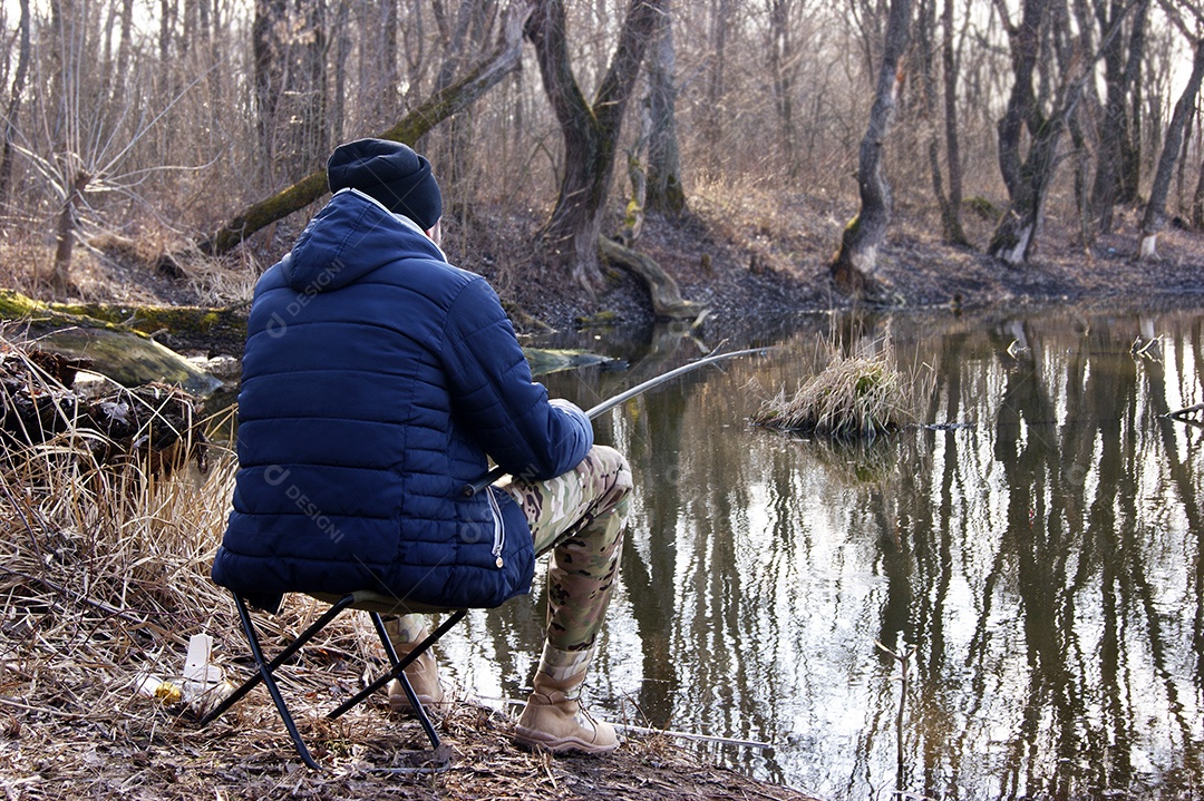 Vara de pesca nas mãos de um pescador no lago