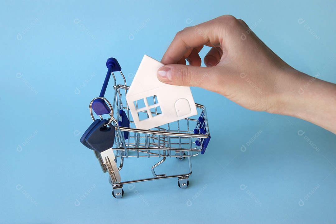Carrinho de compra com chave pendurada e uma casa de papel