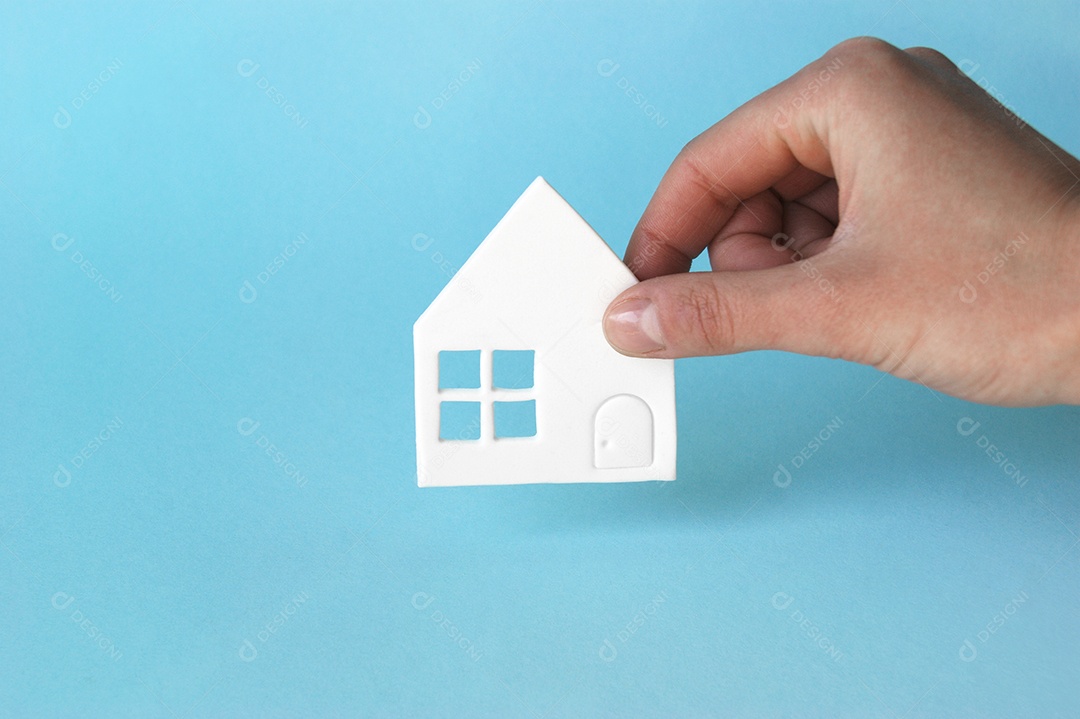 Mão segurando mini casa de papel