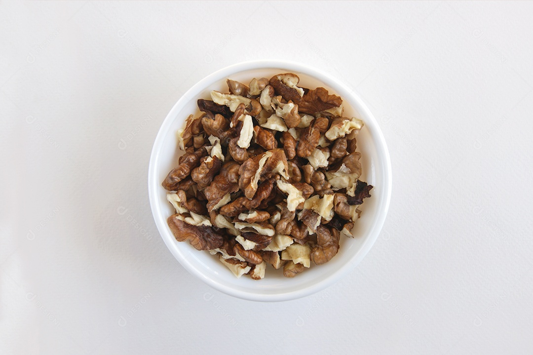 Vasilha branca com nozes dentro sobre fundo branco