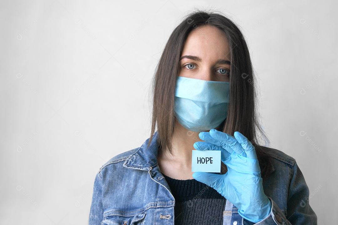 Mulher usando máscara segurando papel escrito esperança