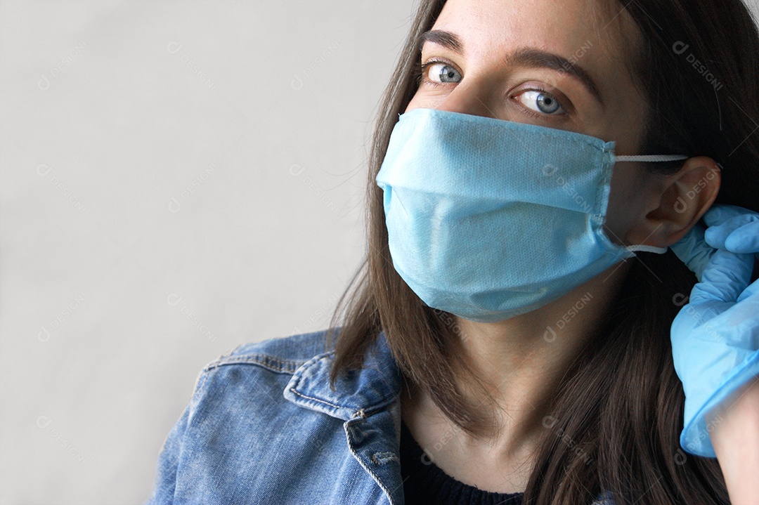Mulher de luva colocando máscara azul