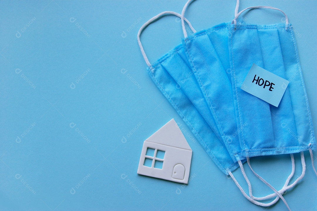 Máscara e mini casa branca sobre fundo azul