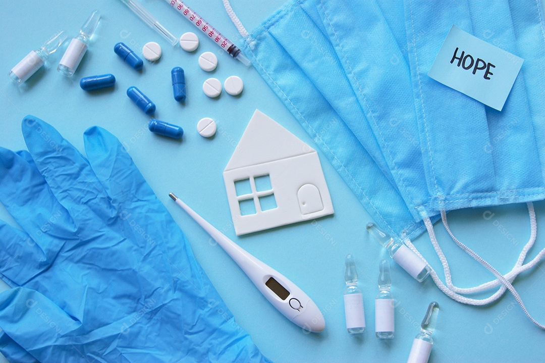 Luvas máscaras termômetro e alguns remédios sobre fundo isolado azul