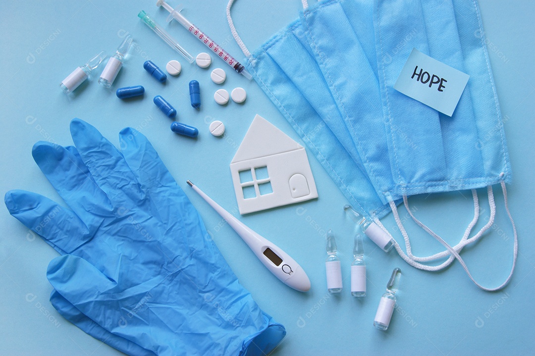 Luvas máscaras termômetro e alguns remédios sobre fundo isolado azul