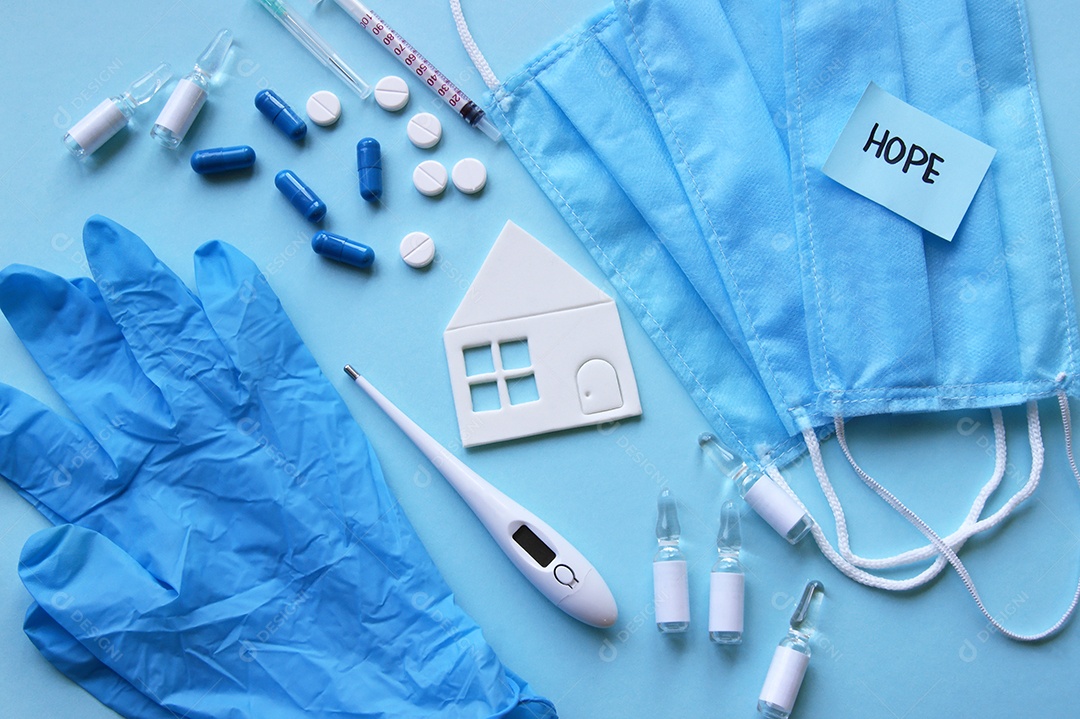 Luvas máscaras termômetro e alguns remédios sobre fundo isolado azul