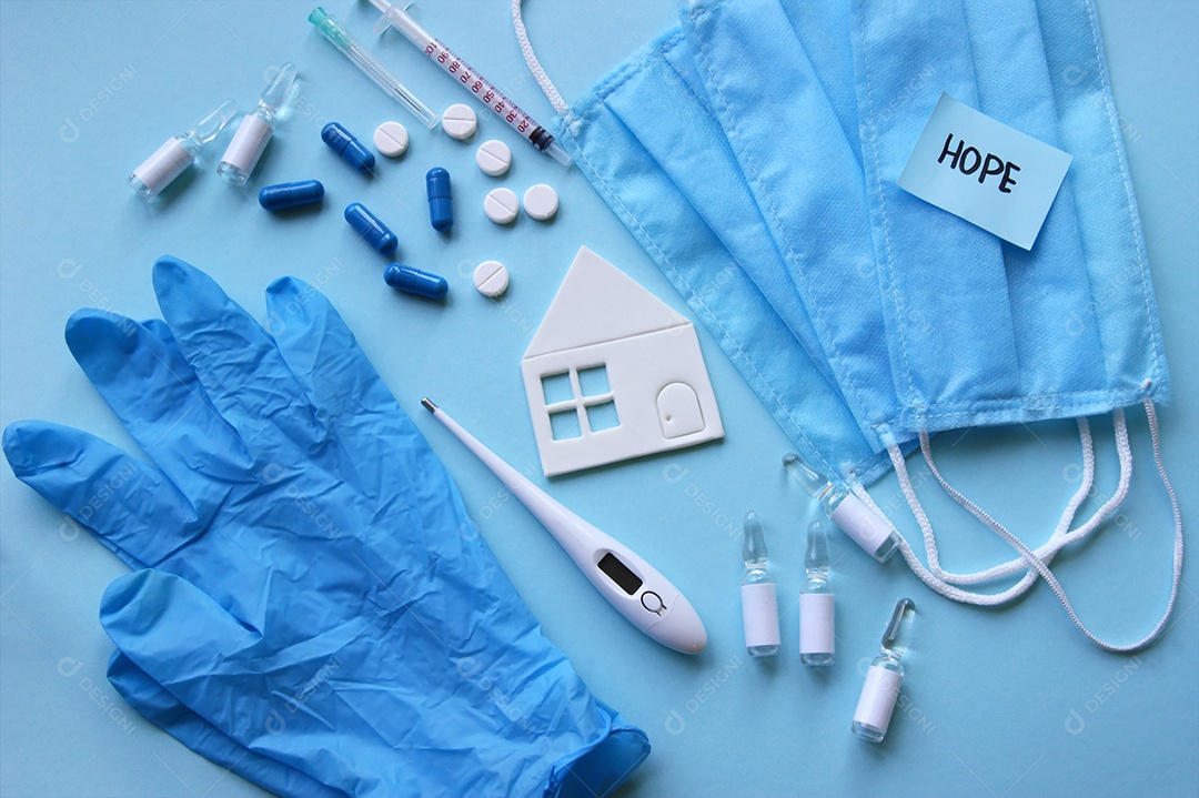 Luvas máscaras termômetro e alguns remédios sobre fundo isolado azul