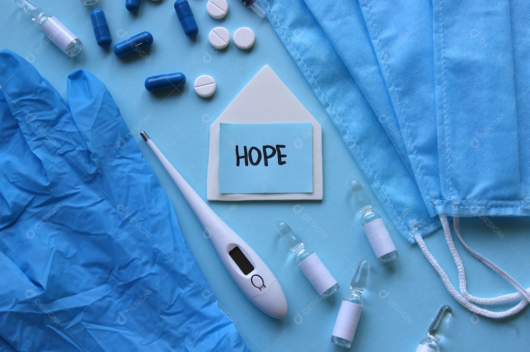 Luvas máscaras termômetro e alguns remédios sobre fundo isolado azul