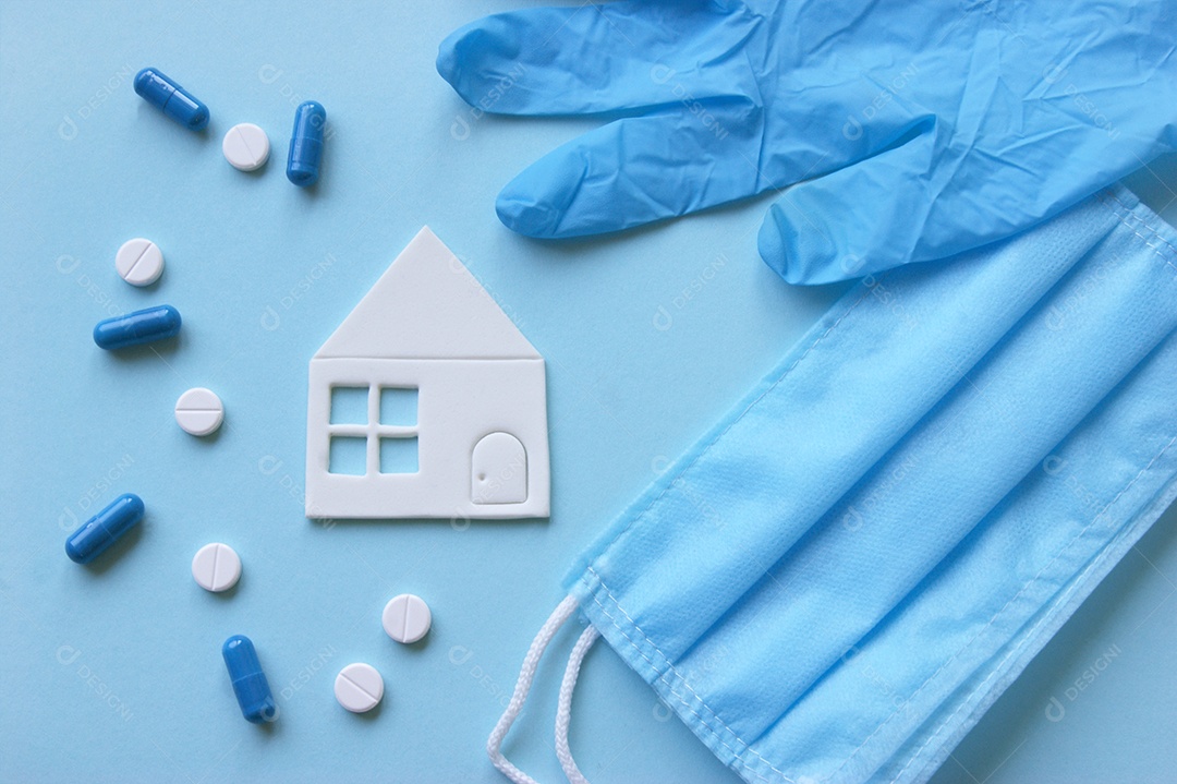 Luvas máscaras mini casa e alguns remédios sobre fundo isolado azul