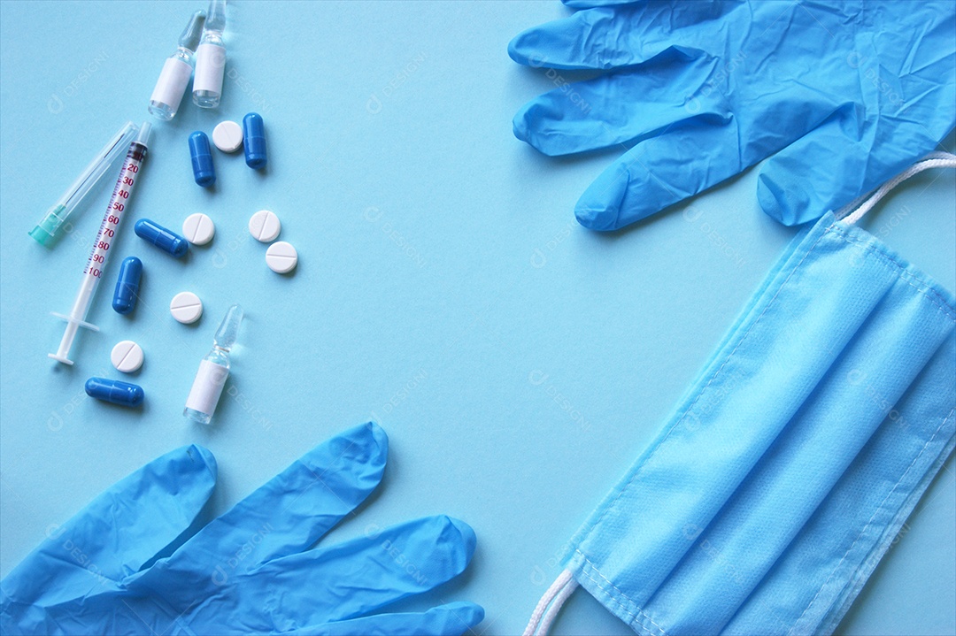 Luvas máscaras seringa e alguns remédios sobre fundo isolado azul