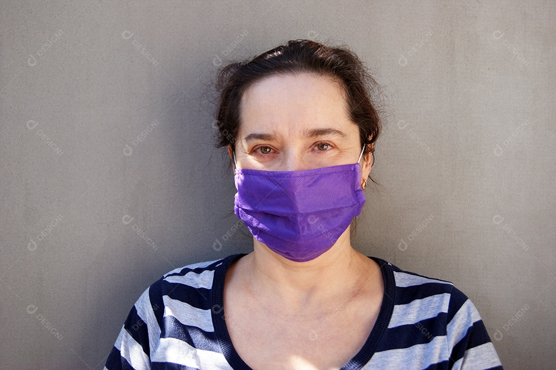 Mulher de olhos claros usando máscara roxa