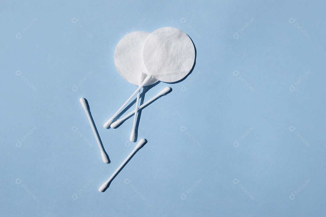 Cotonetes e disco de algodão sobre fundo azul claro