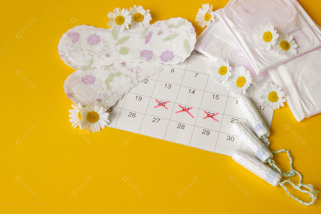 Absorventes calendário e comprimidos sobre fundo amarelo