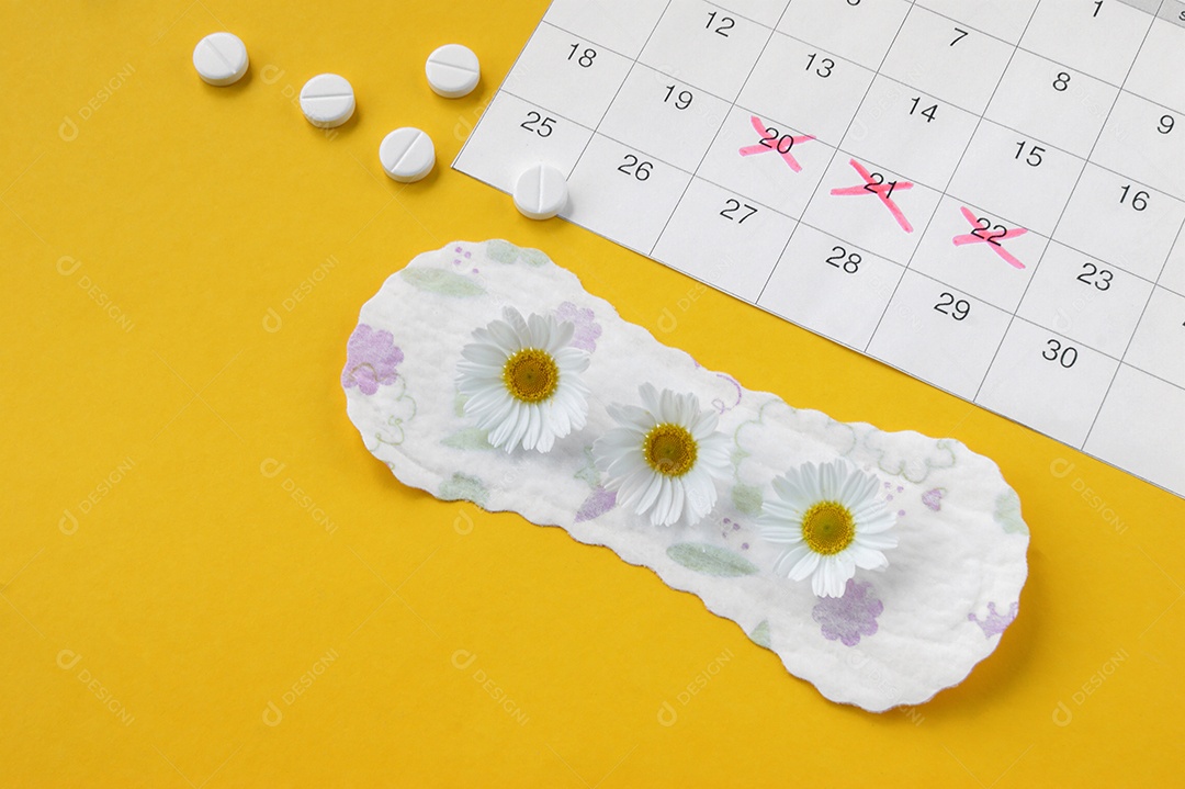 Absorvente calendário e comprimido sobre fundo amarelo