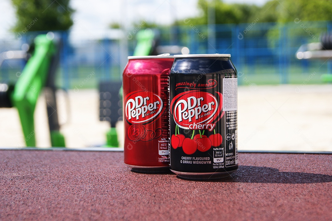 Duas lata de refrigerante DrPepper em cima de bancada e de fundo uma academia ao ar livre