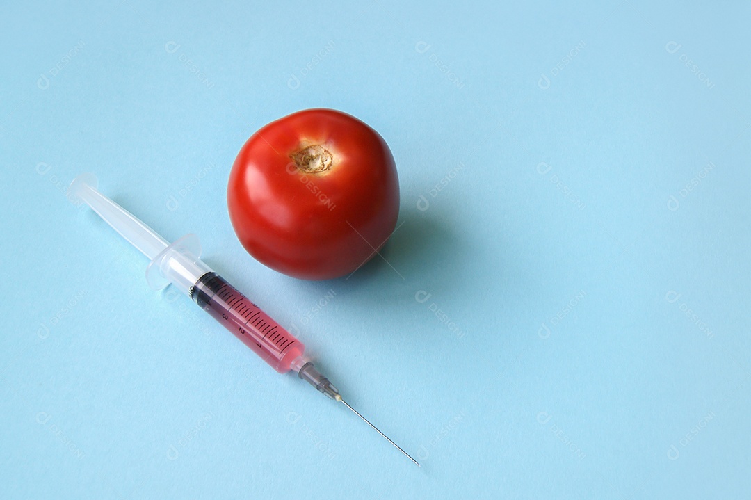 Tomates e seringa sobre fundo azul