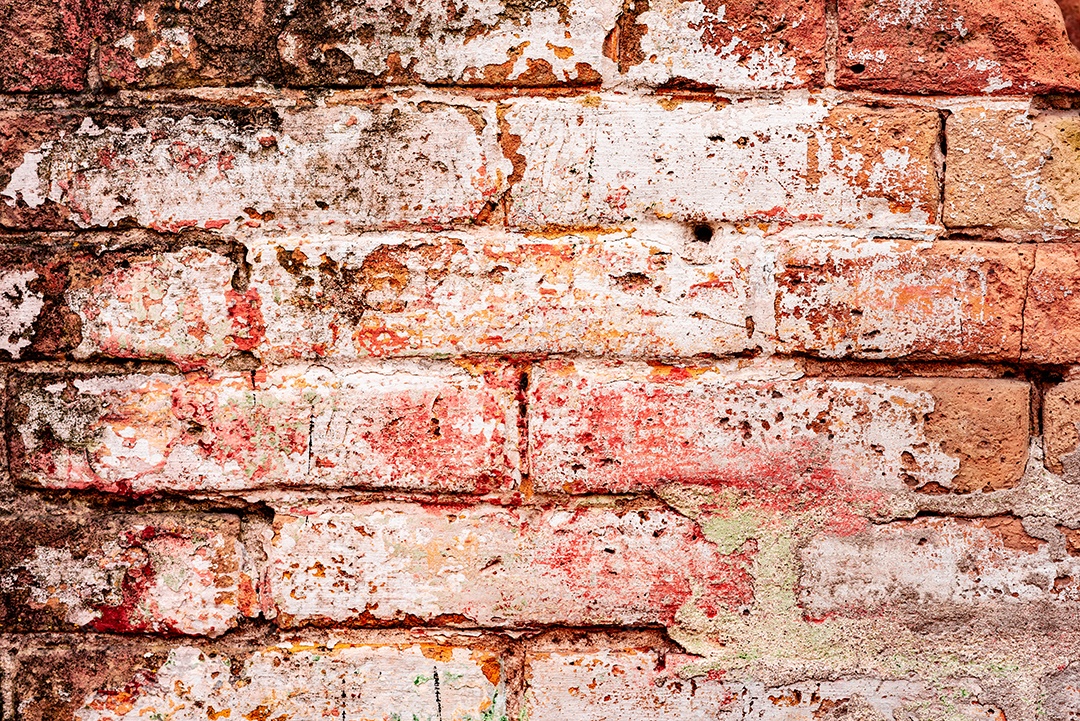 Textura de uma parede de tijolos com rachaduras e arranhões que podem ser usadas como fundo