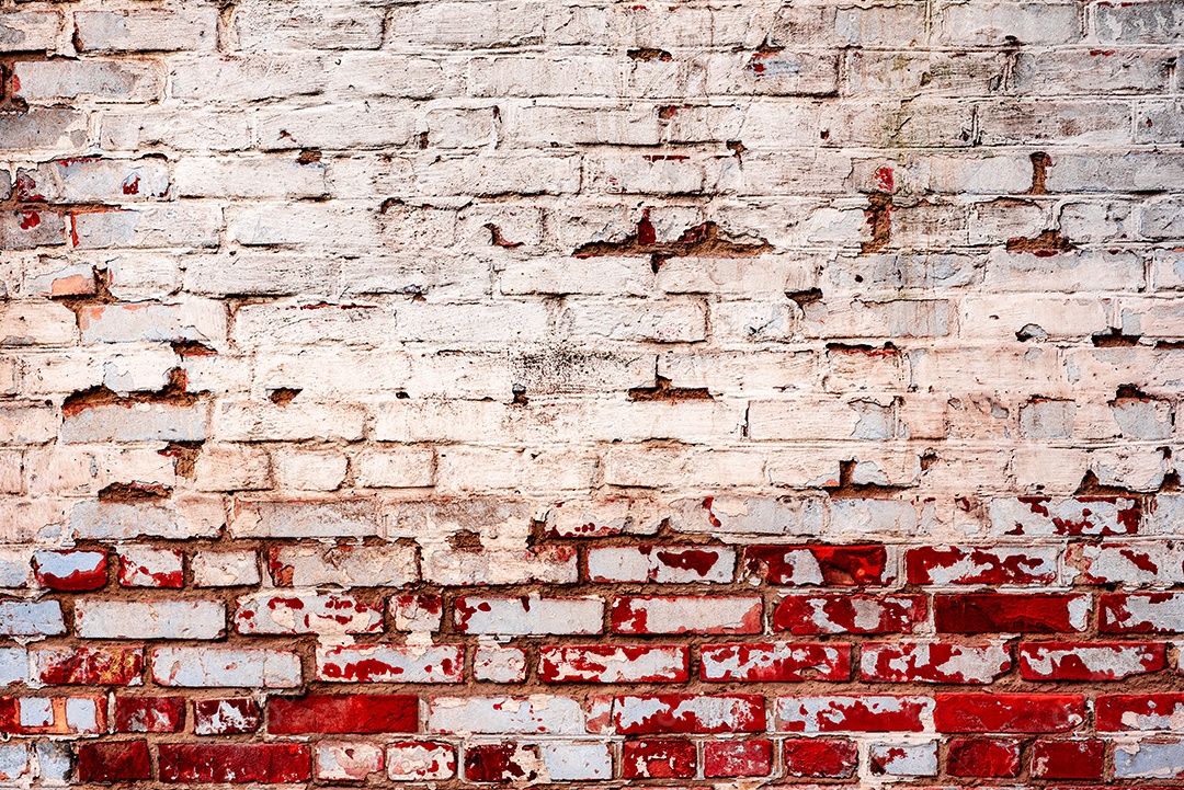 Textura de uma parede de tijolos com rachaduras e arranhões que podem ser usadas como fundo