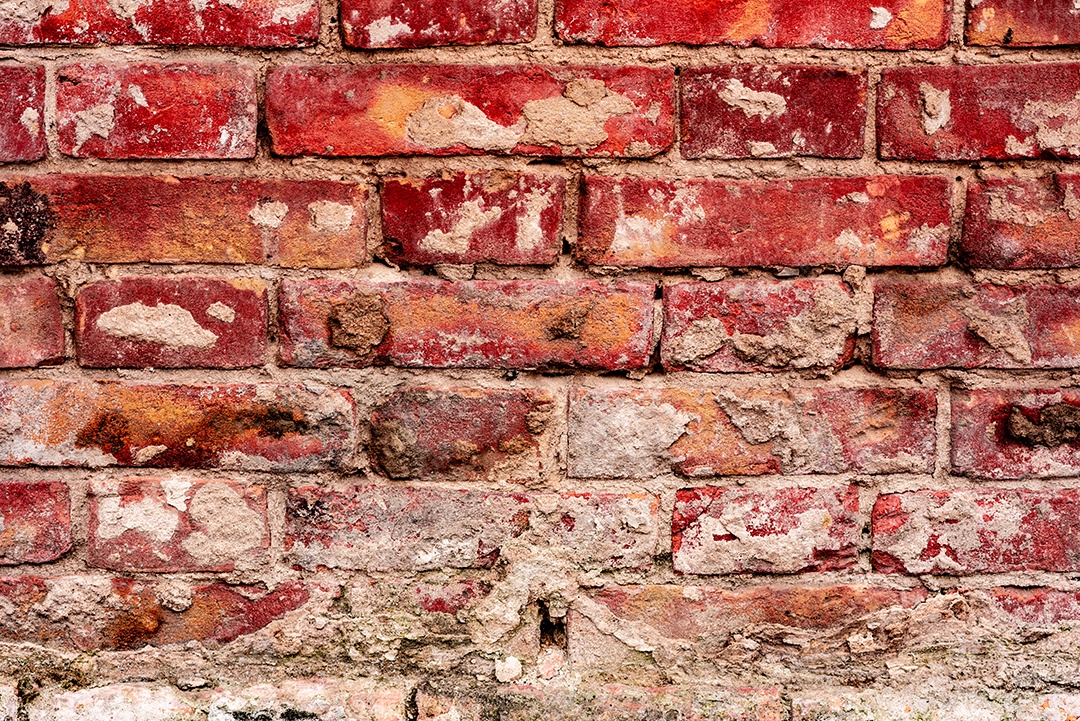 Textura de uma parede de tijolos com rachaduras e arranhões que podem ser usadas como fundo