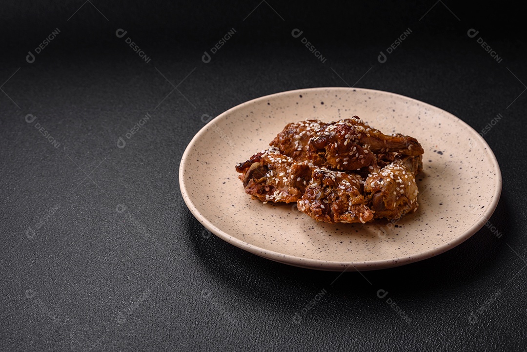 Salada quente com vitela, tomate, pimentão, abobrinha, gergelim, sal, especiarias e ervas sobre fundo escuro de concreto