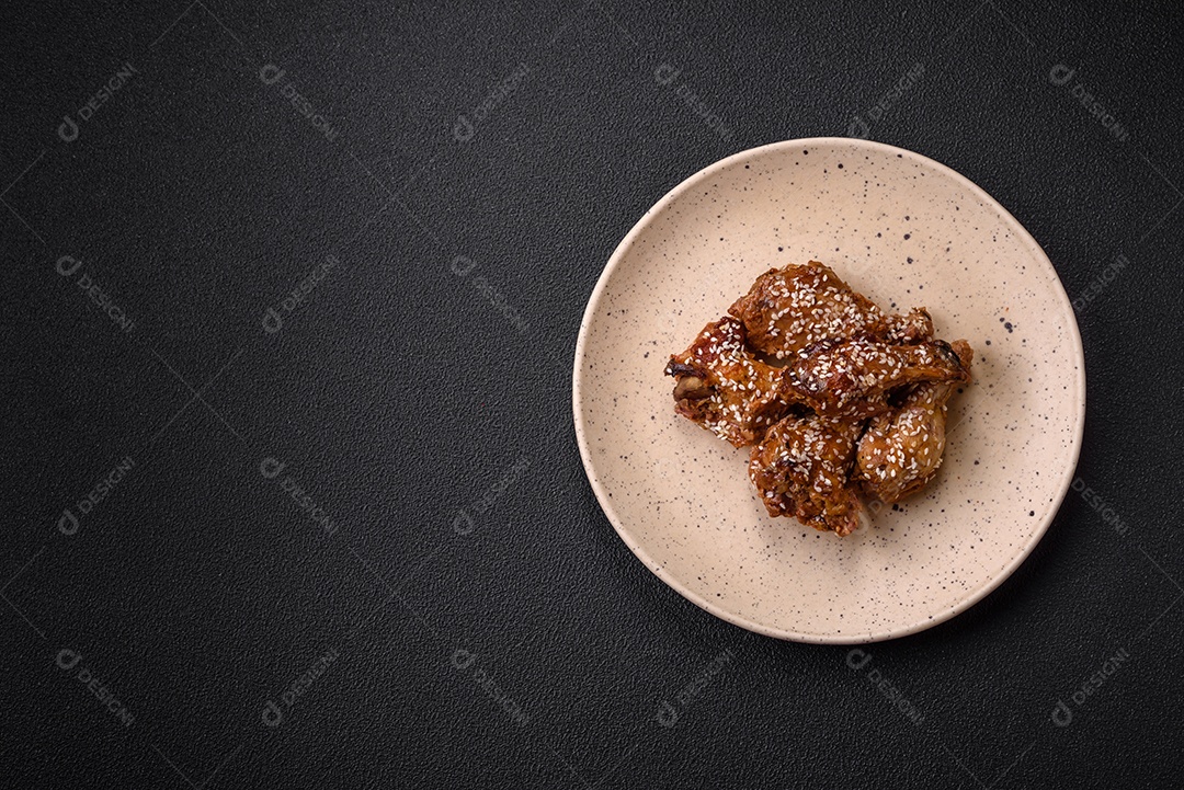 Salada quente com vitela, tomate, pimentão, abobrinha, gergelim, sal, especiarias e ervas sobre fundo escuro de concreto