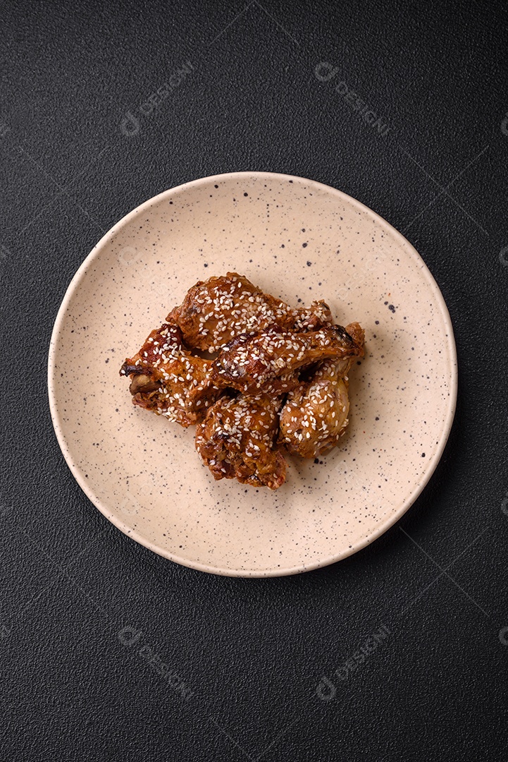 Salada quente com vitela, tomate, pimentão, abobrinha, gergelim, sal, especiarias e ervas sobre fundo escuro de concreto