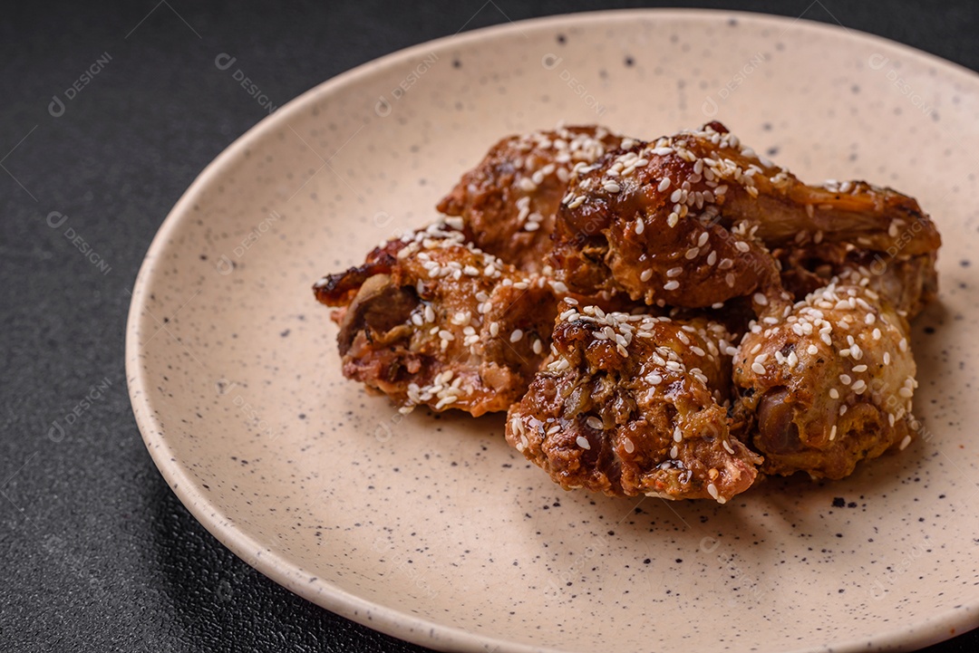 Salada quente com vitela, tomate, pimentão, abobrinha, gergelim, sal, especiarias e ervas sobre fundo escuro de concreto