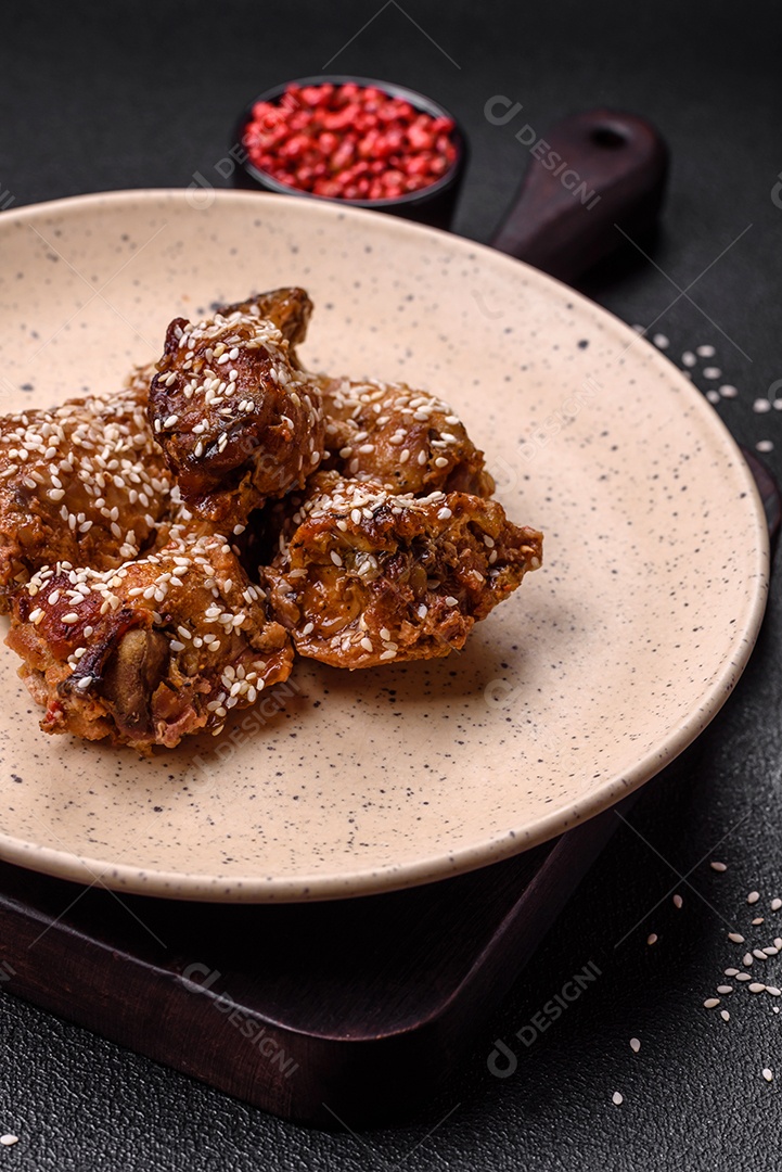 Salada quente com vitela, tomate, pimentão, abobrinha, gergelim, sal, especiarias e ervas sobre fundo escuro de concreto