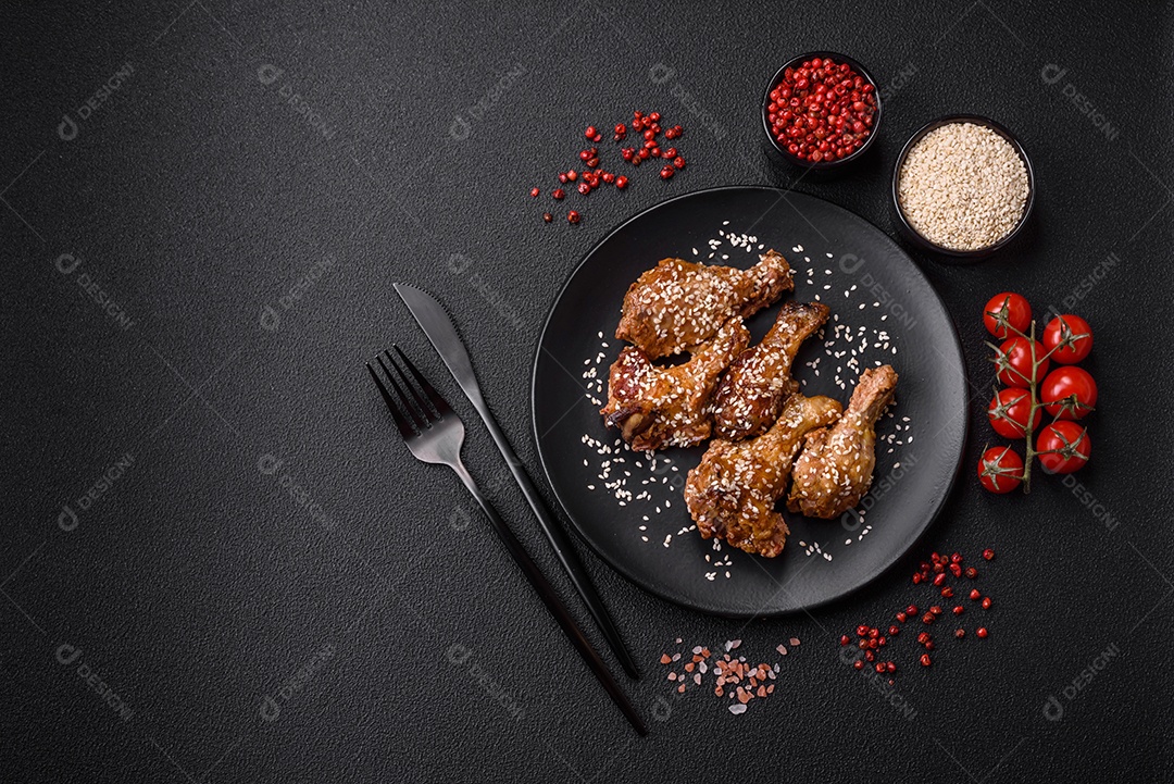 Deliciosas asas de frango grelhado com sal, especiarias e molho teriyaki sobre um fundo escuro de concreto