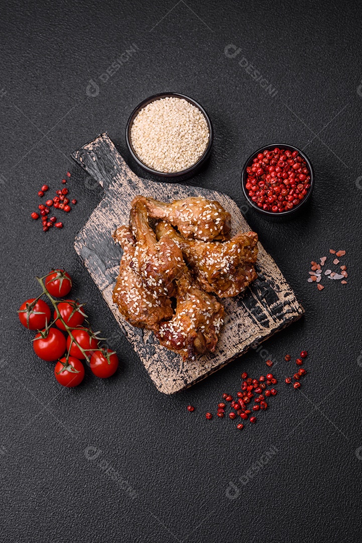 Salada quente com vitela, tomate, pimentão, abobrinha, gergelim, sal, especiarias e ervas sobre fundo escuro de concreto