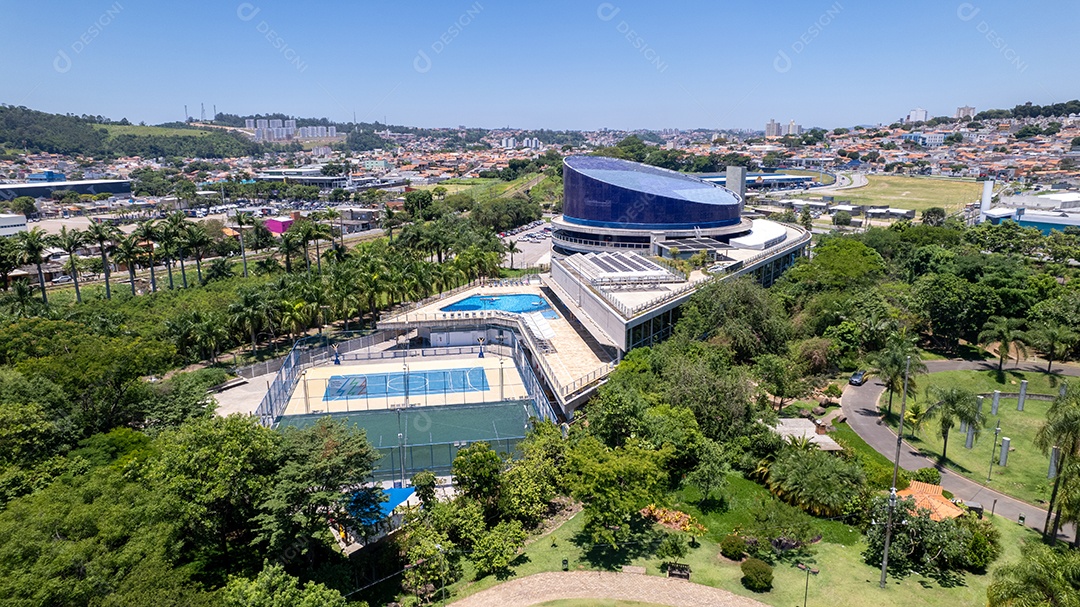 Vista de um clube bonito com piscinas e quadras.