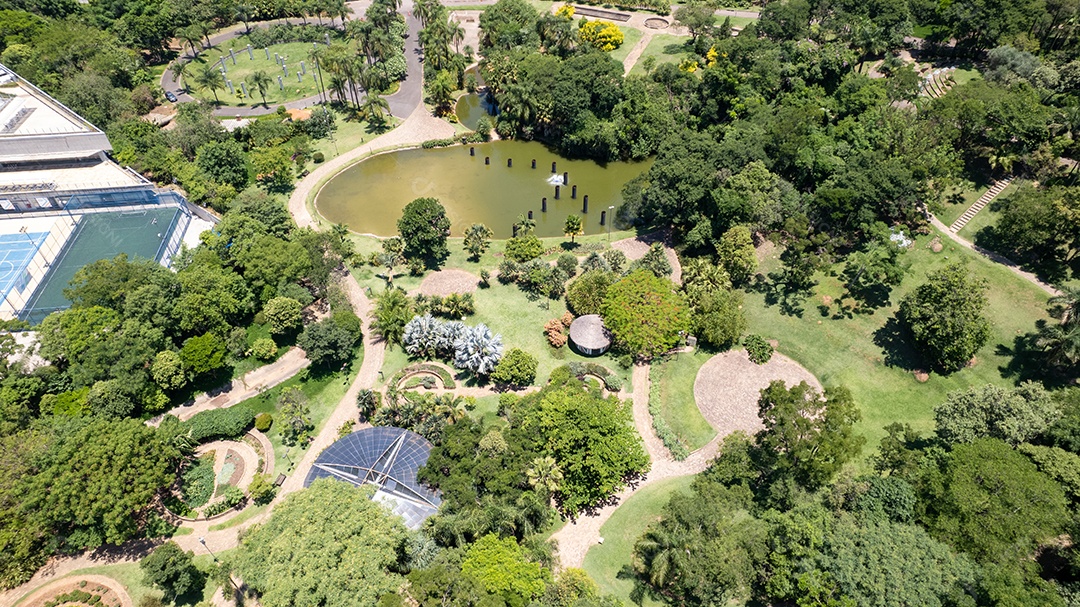 Praça linda com muita árvores e uma lagoa.