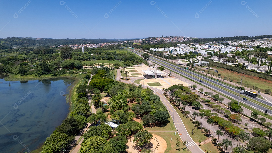 Vista aérea de uma avenida e um lago ao lado.