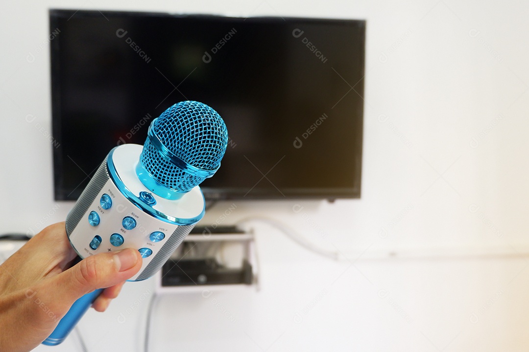 Mão do homem segurando um microfone para cantar