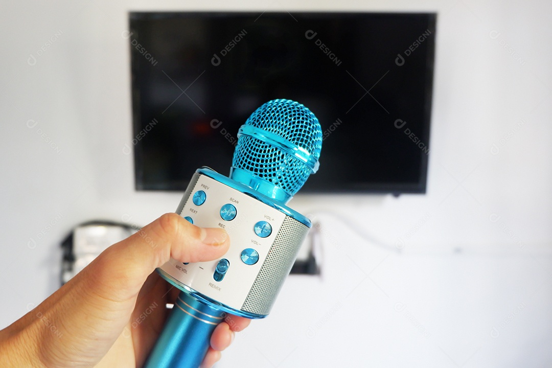 A mão do homem segurando um microfone para cantar