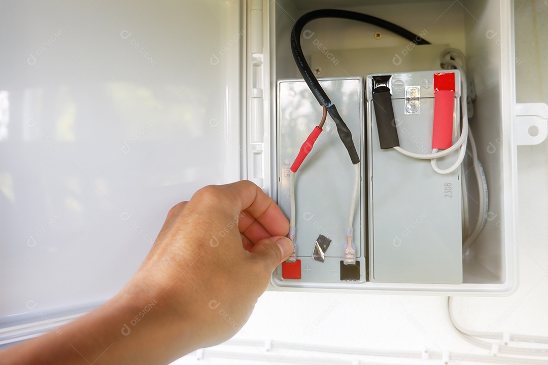 Mãos de homem instalando baterias no gabinete