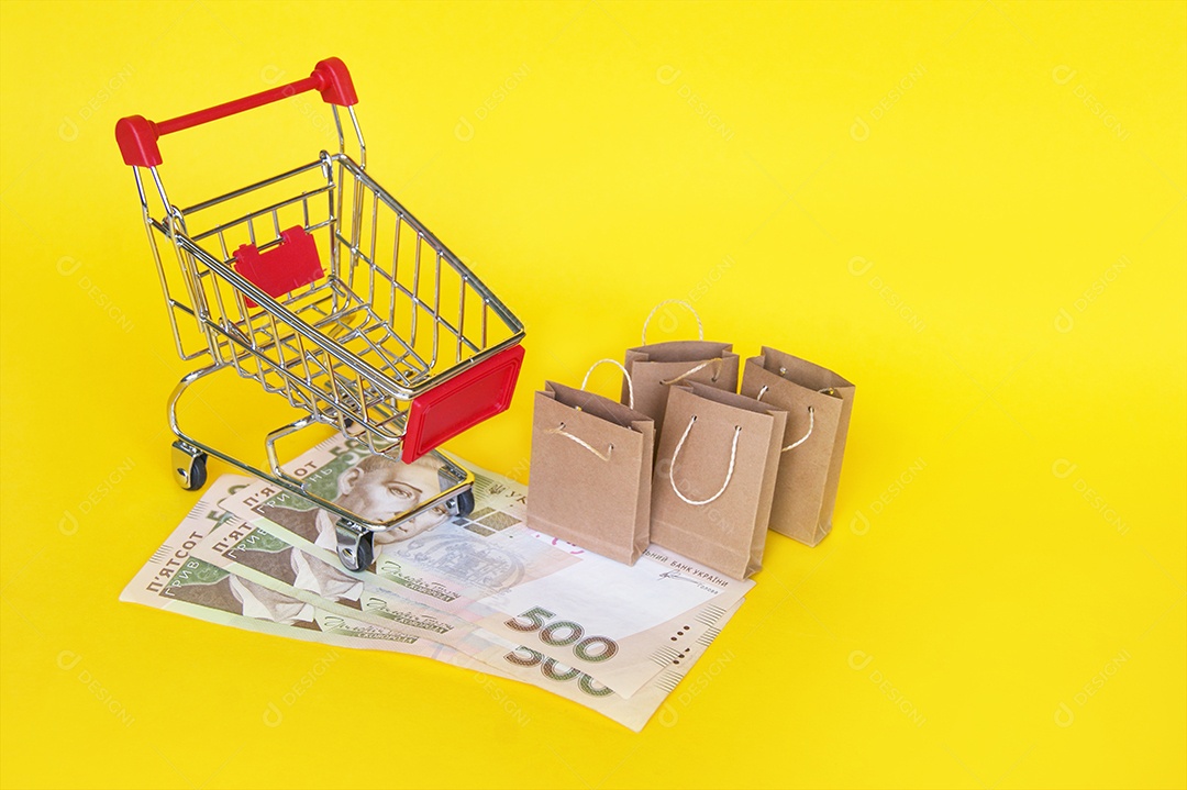 Carrinho com dinheiro embaixo e sacolas de compras ao lado