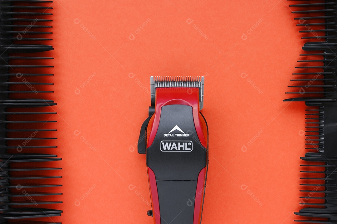 Pentes e maquina de cortar cabelo sobre fundo vermelho