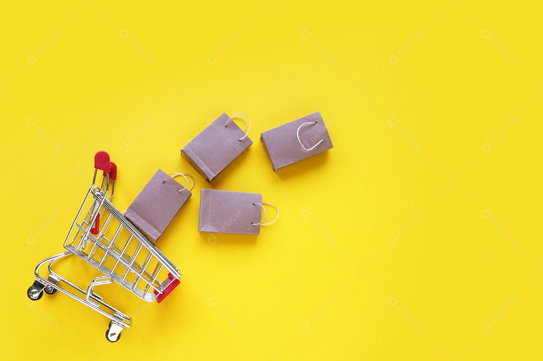 Carrinho de compra caído junto de sacolas