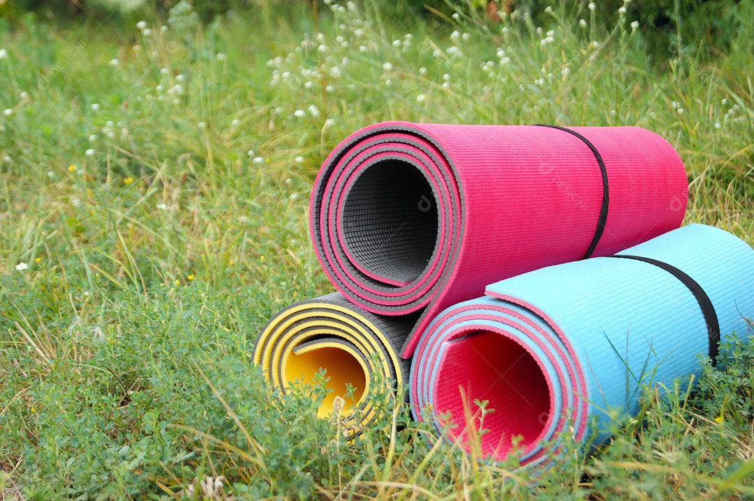 Tapete de ioga coloridos sobre gramado