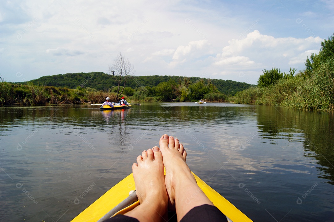 Família remando em um caiaque amarelo nas margem do rio muitas árvores