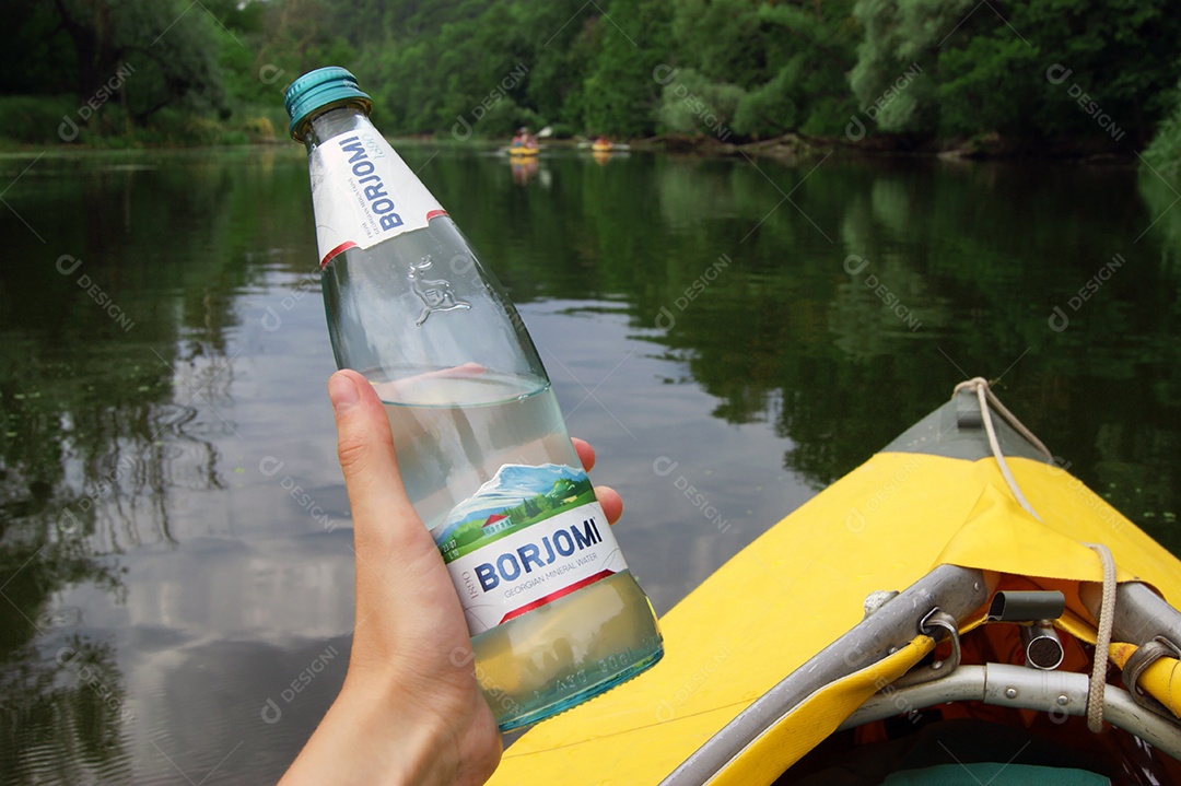 Uma pessoa de caiaque segurando garrafa de água