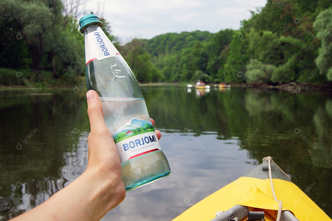 Uma pessoa no caiaque segurando garrafa de água