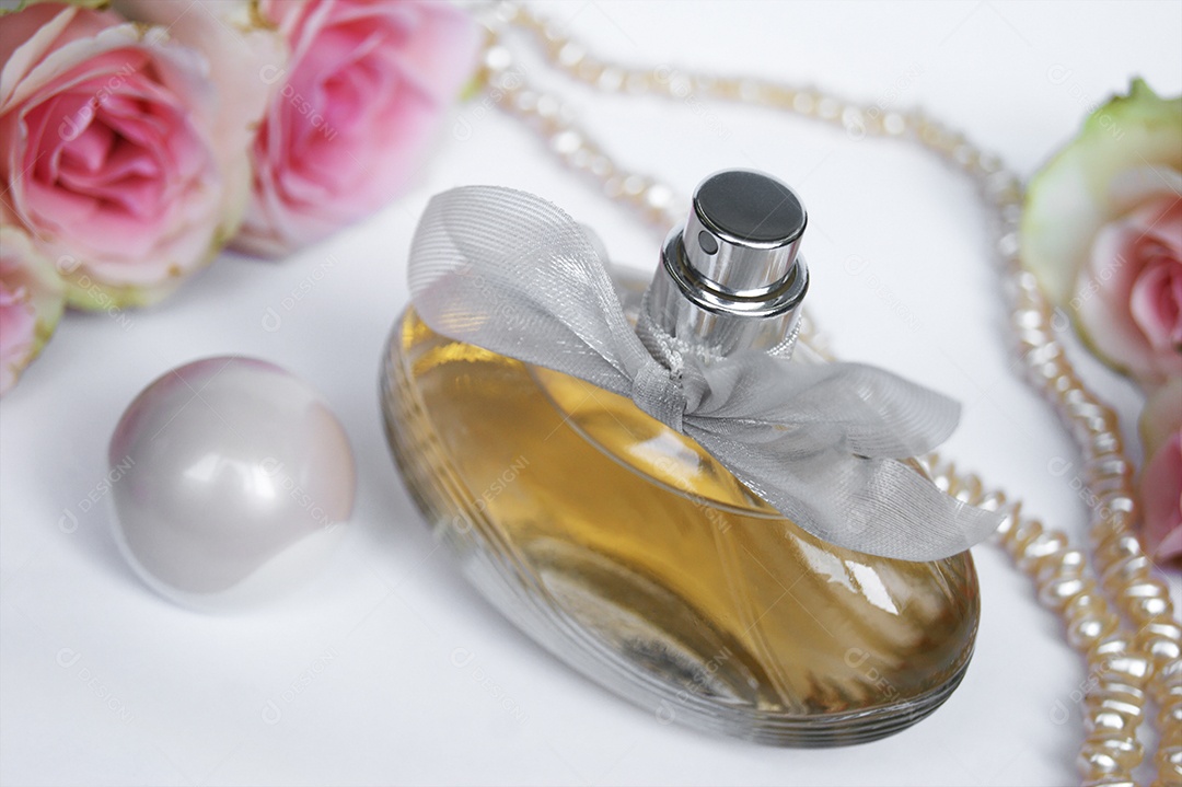 Frasco de perfume com tampa ao lado flores e pétalas