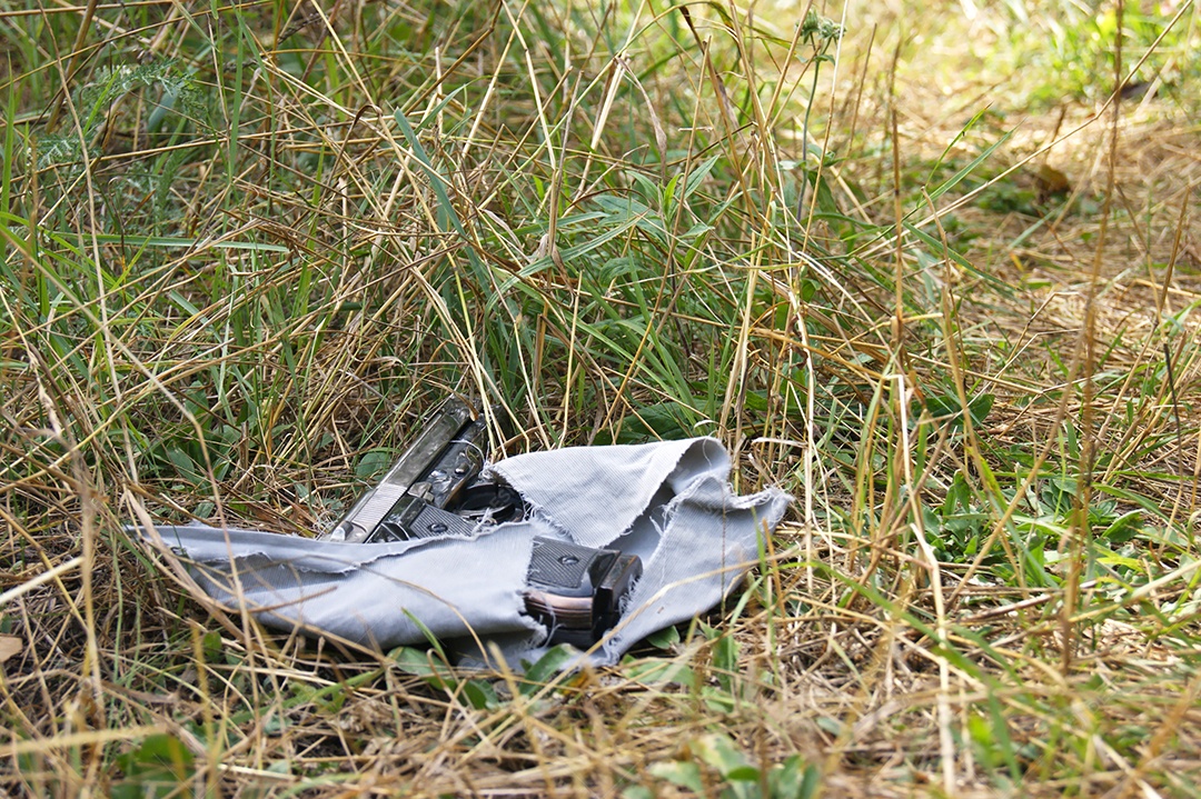 Arma no chão de uma mata